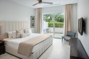 a bedroom with a large bed and a balcony at Garden Villa Condo at ONE Cable Beach in Nassau