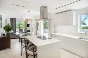 a kitchen with white cabinets and a table and chairs at Garden Villa Condo at ONE Cable Beach in Nassau
