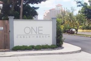 a one cubic beach sign on the side of a street at Garden Villa Condo at ONE Cable Beach in Nassau