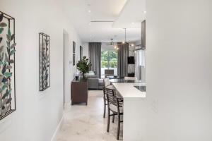 a kitchen and living room with white walls and a table and chairs at Garden Villa Condo at ONE Cable Beach in Nassau