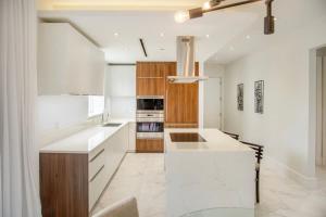 a kitchen with white countertops and wooden cabinets at Garden Villa Condo at ONE Cable Beach in Nassau +34 photos