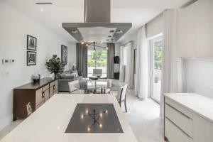 a white living room with a table and a couch at Garden Villa Condo at ONE Cable Beach in Nassau