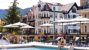 a woman in a bikini sitting by a pool at a hotel at The Landmark in Vail