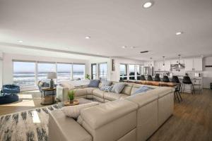 a living room with a large couch and a kitchen at The Sandmark in Rockaway Beach