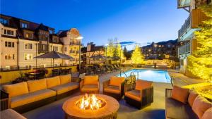 a patio with couches and a fire pit and a pool at The Landmark in Vail