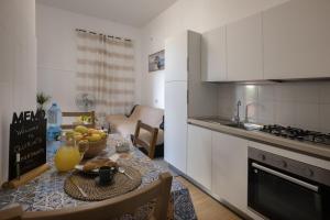 a kitchen with a table with a bowl of fruit on it at Quirin's Apartments in Taormina