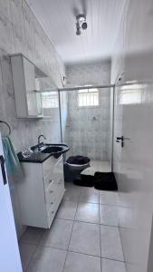a white bathroom with a toilet and a sink at Casa Campos do Jordão in Campos do Jordão