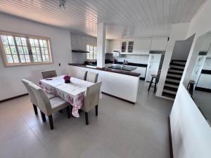 uma cozinha e sala de jantar com mesa e cadeiras em Casa Campos do Jordão em Campos de Jordão