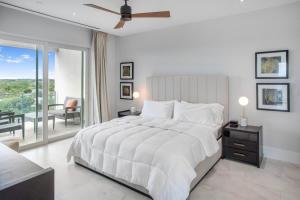a white bedroom with a large bed and a balcony at One bedroom condo at ONE Cable Beach in Nassau +20 photos