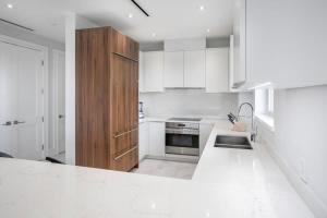 a kitchen with white cabinets and a white counter top at One bedroom condo at ONE Cable Beach in Nassau