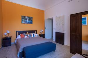 a bedroom with a king sized bed and orange walls at Quirin's Apartments in Taormina