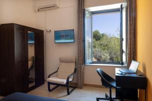 an office with a chair and a desk and a window at Quirin's Apartments in Taormina