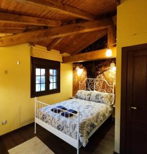 a bedroom with a white bed in a room with yellow walls at Casa Rural La Genciana VALMALA in Valmala