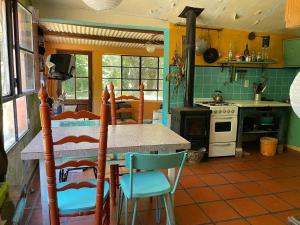a kitchen with a table and chairs and a stove at La Calabaza in Punta Indio
