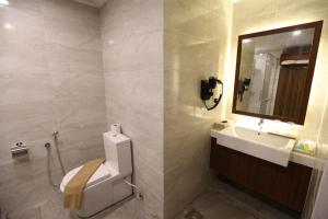 Un baño con lavabo, inodoro y espejo. en Residenz Apartments in Amerald Resort Hotel Desaru, en Desaru 5 fotos más