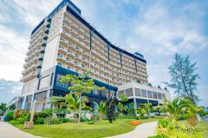 un gran edificio de hotel con un parque enfrente en Residenz Apartments in Amerald Resort Hotel Desaru, en Desaru