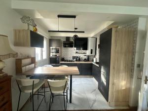 eine Küche mit einem Holztisch und einigen Stühlen in der Unterkunft Centre ville in Le Mans