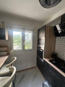 eine Küche mit Geräten aus Edelstahl und einem Fenster in der Unterkunft Centre ville in Le Mans