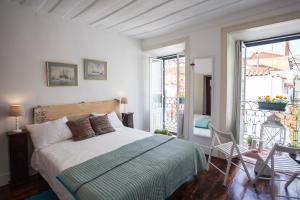 リスボンにあるLisbon Inn Bica Suitesのベッドルーム(ベッド1台付)、バルコニーが備わります。