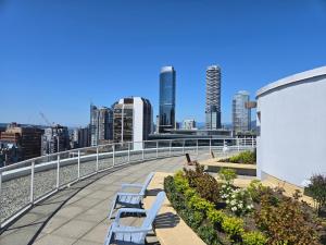 a row of blue benches on a balcony with a city skyline at New York Style Loft in Downtown Vancouver in Vancouver