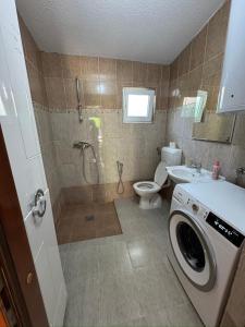 a bathroom with a shower and a washing machine at Resting House Oaza in Bihać