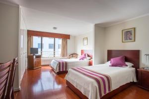 una camera d'albergo con due letti e una televisione di MR Apart Providencia (ex Apart Neruda) a Santiago