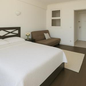 sypialnia z białym łóżkiem i kanapą w obiekcie Monaco Scala Suite Rickeys w Monte Carlo