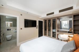 a bedroom with a white bed and a bathroom at Charles of Mayfair in London