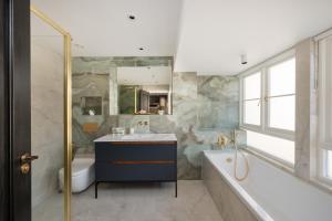 a bathroom with a tub and a sink and a bath tub at Charles of Mayfair in London +37 photos