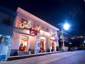 a white building at night with a street light at Hotel y Restaurante El Peregrino in Flores