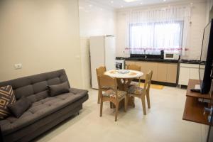 a living room with a couch and a table and a kitchen at Condominio Pagani in Foz do Iguaçu