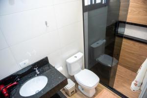 a bathroom with a white toilet and a sink at Condominio Pagani in Foz do Iguaçu +17 photos