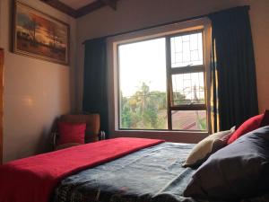 a bedroom with a bed and a large window at All the Way in Hartbeespoort