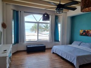 a bedroom with a bed and a large window with the beach at Casa Columpios, con alberca a pasos de la playa in Chuburná +29 photos
