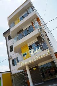 a building with a dmgume service sign on it at Hotel Diamante Sarare 2 in Saravena