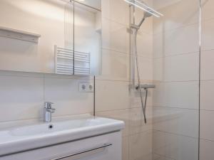 a white bathroom with a sink and a shower at Le Soleil in Bruck an der Großglocknerstraße +23 photos