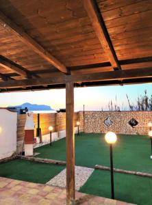 a patio with a green lawn with lights on it at VILLA HEMINGWAY - LA CASA DI LEONARDO in Ficarazzi