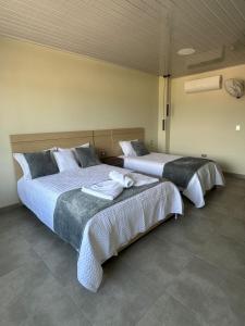 two beds sitting in a room with at Hotel Diamante Sarare 2 in Saravena +22 photos