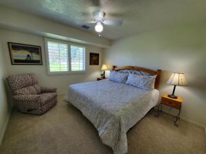 a bedroom with a bed and a chair and a window at Windmill Ranch in Chino Valley