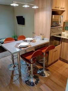 a kitchen with a table with chairs and a counter top at Departamento 2 Habitaciones 2 Baños 4 Camas Indivuduales in Calama +4 photos