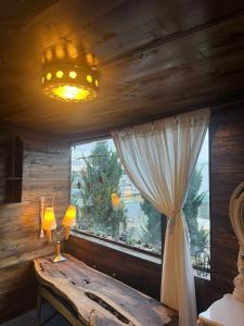 a bedroom with a window and a table with a lamp at Nhà Của Sen in Da Thien