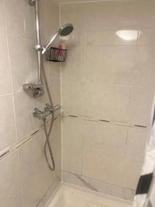 Forest HillにあるCozy Two Bedroom Flat 1 Minute from Forest Hill Train Stationの浴室のシャワーヘッド付きシャワー