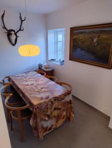 a dining room with a wooden table and chairs at Langemose Bed&Bath in Ringsted