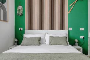 a bedroom with a white bed with a green wall at Oasis Suite - Subway 50 meters just 5 minutes from Duomo in Milan