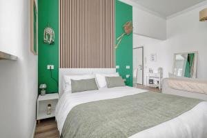 a bedroom with a large bed with green and white walls at Oasis Suite - Subway 50 meters just 5 minutes from Duomo in Milan