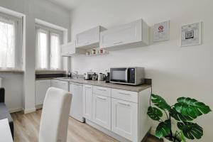 a kitchen with white cabinets and a microwave at Oasis Suite - Subway 50 meters just 5 minutes from Duomo in Milan