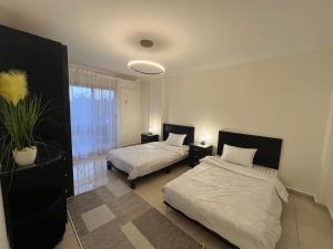a bedroom with two beds and a window at Property Sisters Madinaty, Elite garden view B2 in Madinaty