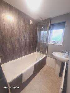 a bathroom with a bath tub and a sink at South Shields Executive Apartment in South Shields