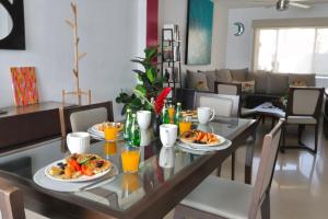 a dining room table with plates of food and orange juice at Lomas del Sol in Jarretadera
