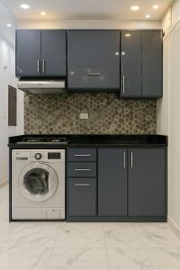 塞得港Escape to serenity in Porto Saids finest chalets的厨房配有黑色橱柜和洗衣机。